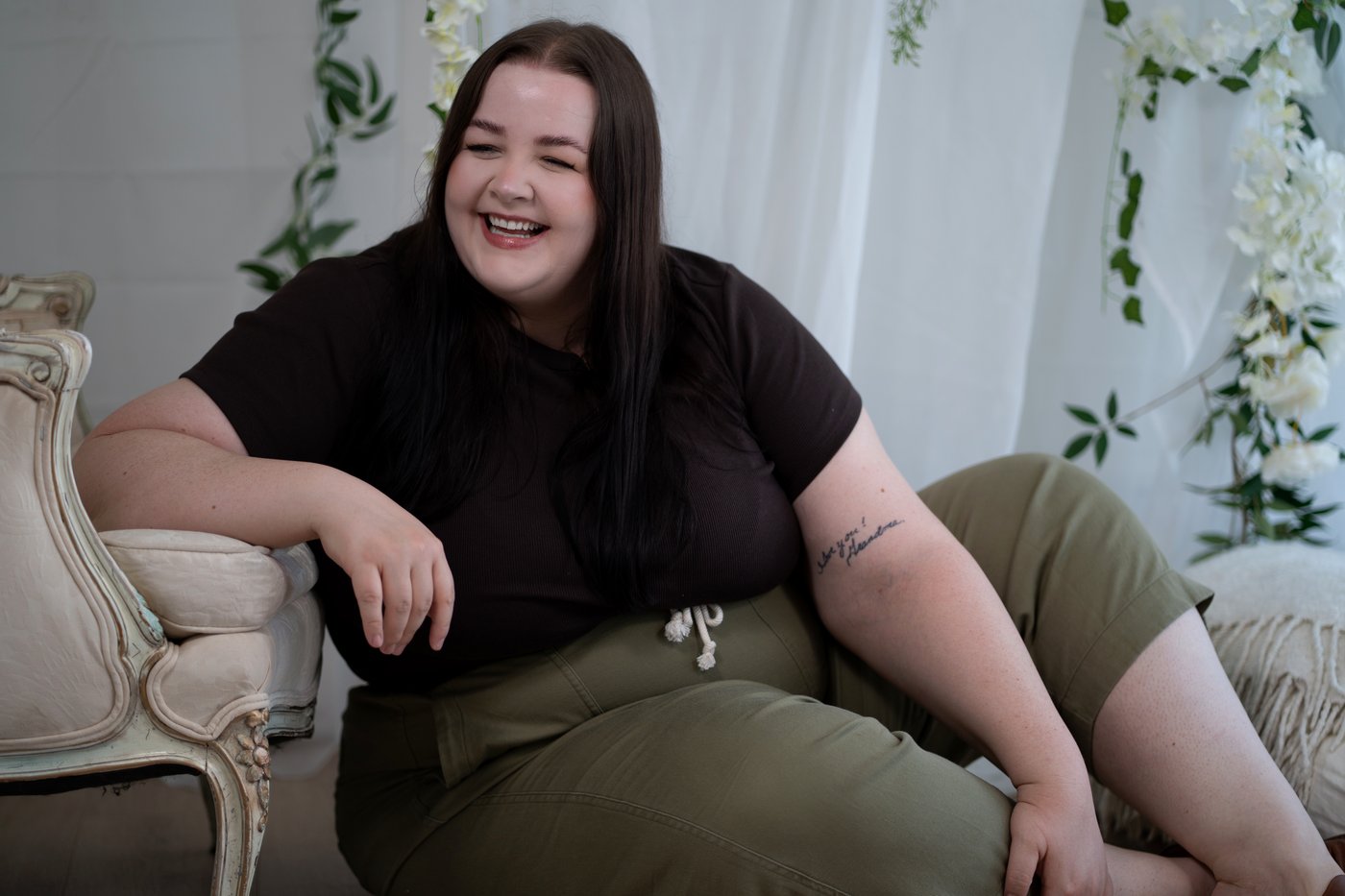 Kayla Martinez laughing in an armchair
