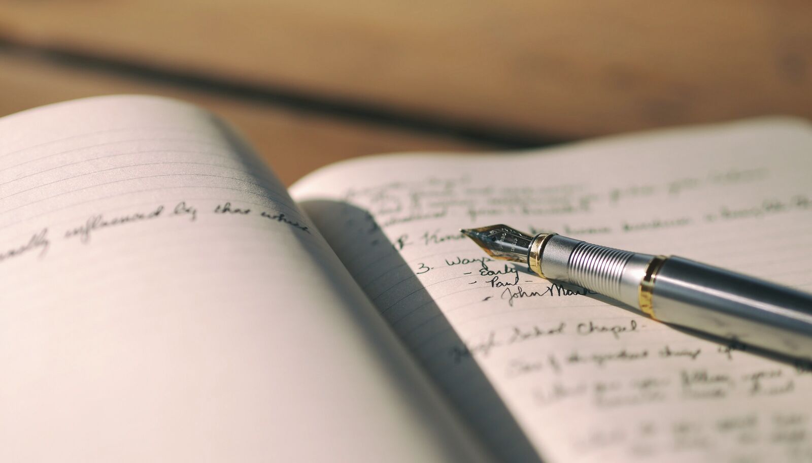 A fountain pen resting on an open, handwritten journal